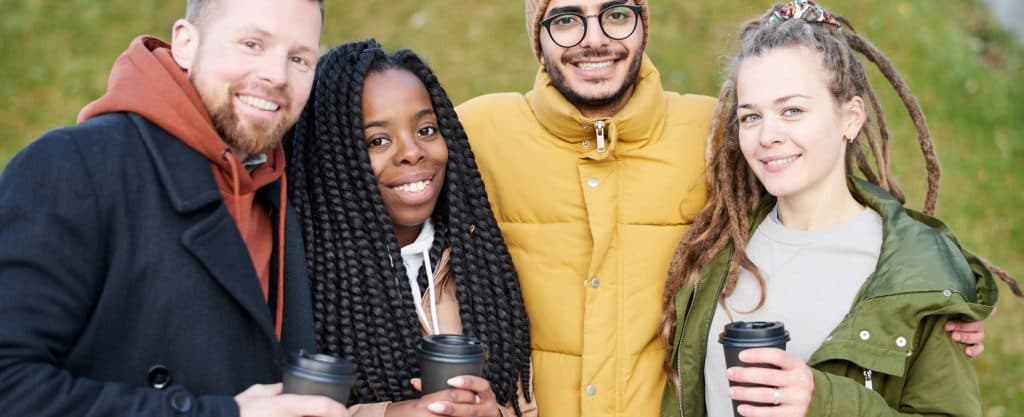 Smiling team members holding coffee